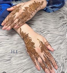 two hands with henna tattoos on them