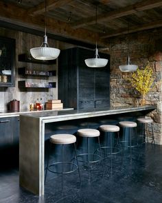 an image of a bar with stools in the middle and lights hanging from the ceiling