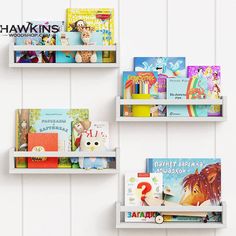 three bookshelves with children's books on them against a white painted wall