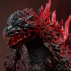 a close up of a godzilla figure with red lighting on it's eyes and mouth