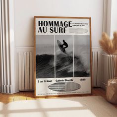 a surfboarder riding a wave in front of a large poster on the wall