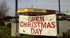 an open christmas day sign in front of a store on the side of the road