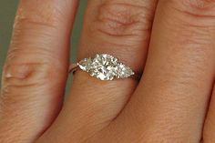 a woman's hand with an engagement ring on it