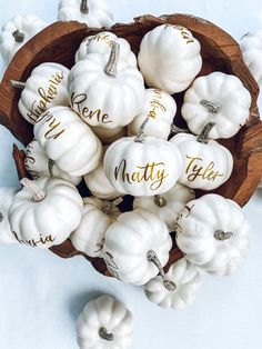 white pumpkins with names on them sitting in a bowl