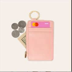 a pink card case with two coins and a keychain on top of it