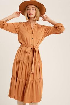 -Color: Butter Scotch -Twill textured rayon -V-neck -Pockets on front chest -Elasticized on waist -Button on cuffs -Roll up dolman sleeves -Waist tie with self string -Curved hem -Content: Self 100% Rayon; Lining 100% Polyester -Hand wash/Line dry -Imported -Model is 5' 10" 34-24-35 wearing a size Small Fall V-neck Shirt Dress With Pockets, Brown Button-up Fall Midi Dress, V-neck Midi Dress With Button Closure, Winter V-neck Midi Dress With Button Closure, Cotton V-neck Midi Dress With Button Closure, Corduroy Button-up Dress With Button Closure, Oversized Turtleneck Sweater, Oversized Turtleneck, Fringe Jacket