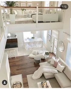 a living room filled with white furniture and lots of windows on top of it's walls