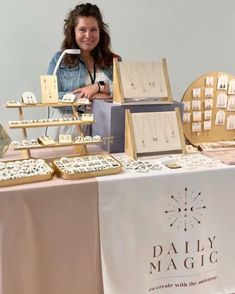 a woman standing next to a table full of jewelry