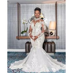 a woman standing in front of a mirror wearing a wedding dress