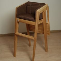 a wooden chair sitting on top of a hard wood floor next to a white wall