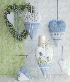 three heart shaped ornaments hanging on the wall next to a candle and some other decorations