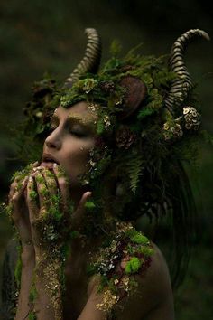 a woman is covered in moss and plants