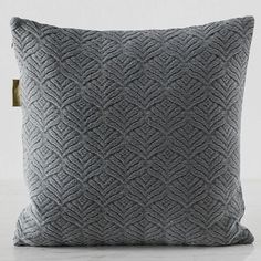 a grey pillow with an intricate design on it