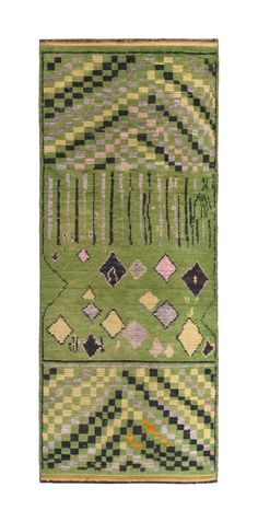 a green rug with black and white squares on it, in the shape of an abstract design