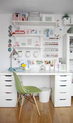 a white desk topped with lots of drawers next to a shelf filled with books and other items