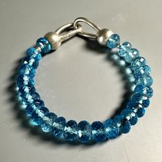 Bracelets, Blue Topaz  Beads in Sterling - Gloria Sawin  Fine Jewelry Blue Topaz Meaning, Topaz Meaning, Arthritic Hands, Beaded Bangles Bracelets, Fire And Stone, Bead Bangles, Gemstone Beaded Bracelets, Fine Jewelry Bracelets, Genuine Turquoise