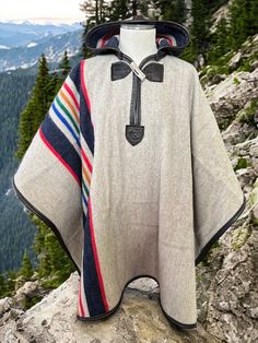 Jypsy Soul Camp Poncho in Pendleton's National Park Series, Yellowstone. Leather trim, natural antler toggle.  Yellowstone is close to our hearts here at Jypsy as it's located in our home state of Wyoming. Here in Wyoming we are surrounded by picturesque mountain ranges including the Big Horn and the Uintas (where our shop is located), and although each has its hidden treasures, Yellowstone is by far the most iconic and this pattern captures it perfectly.  About the wool... "Since the early 1900s, Pendleton Woolen Mills has honored America's National Parks with a collection of distinctive park blankets. Each blanket has a Pendleton label signifying its authenticity and special woven label with the park name and image of an important natural feature. National Park Blankets are still woven r Camp Blanket Poncho, Park Blanket, Blanket Poncho, Pendleton Woolen Mills, Pendleton Wool, Camping Blanket, Mountain Range, Wyoming, Leather Trims