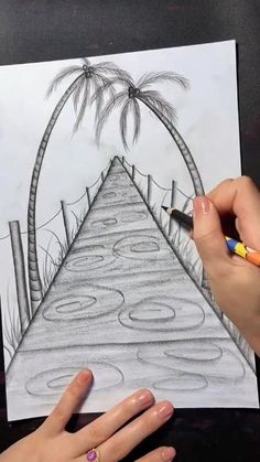 a woman is drawing a palm tree on a piece of paper with colored pencils