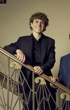 two men in suits are standing on the stairs