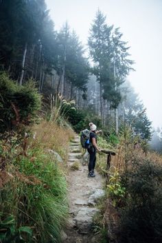 a person with a backpack walking up a trail