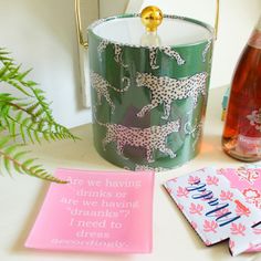 there is a green bucket with pink and white designs on it next to a card