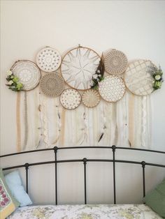 a bed topped with lots of dream catchers hanging on the wall