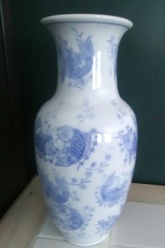 a large blue and white vase sitting on top of a counter next to a wall