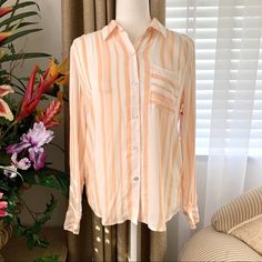 Nwt The Good Jane Sun Ray Micha Shirt Peach The Sun Ray Micha Shirt Is A Classic Fit Long Sleeve Style. It Comes In A Peach/White Vertical Stripe Rayon And Features One Front Pocket. Hand Wash Cold 100% Rayon Lightweight & Flowy, Not Entirely Opaque Flat Measurements Approx Chest 19” Length 23-30” Brand New With Tags, Size S. Model Pics Same Style But Red Color - The Shirt Sold Is In A Peach Orange Color! Brand Sold At Anthropologie. Part Of 3 For $15 Sale! Work Business Casual Pastel Lounge Sch Summer Orange Shirt For Day Out, Orange Shirt For Summer Day Out, Casual Peach Summer Shirt, Chic Orange Shirt For Spring, Spring Orange Shirt For Day Out, Chic Orange Summer Shirt, Casual Peach Blouse For Spring, Casual Peach Blouse For Day Out, Pastel Lounge