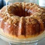 a bundt cake is being drizzled with icing and topped with nuts