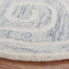 a close up view of a rug on the floor with wood floors in the background