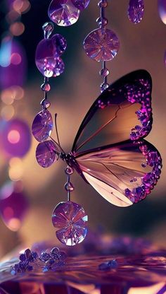 a purple butterfly flying through the air next to some beads and glass balls hanging from it's wings