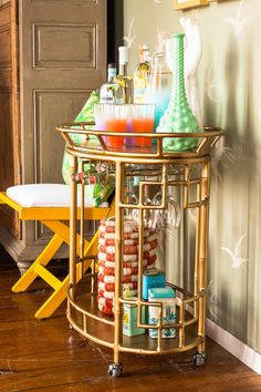 a gold bar cart with drinks on it