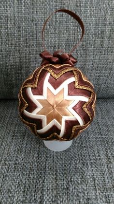 an ornament on the back of a couch with a brown ribbon around it