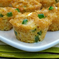 several small muffins on a white plate with green garnishes in them