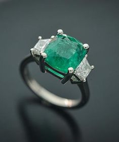 This Elegant Platinum three stone ring has a Natural Cushion Cut Colombian Emerald from the Top Muzo Mine with a GIA Certificate. The side stones are Natural Brilliant Cut Trapezoid Pair of Matching Diamonds. GIA#5202111099 3.34 Carat Cushion Modified 9.64x8.93x5.64 with moderate F2 clarity enchancement. 2 Matching Trapezoid Brilliant Cut Diamonds weigh 0.71 carats total weight and are graded G in color and SI1 to SI2 in clarity. Platinum weight is 5.14 DWT. Ring can be sized. Gia Certificate, Natural Cushions, Platinum Diamond Rings, Three Stone Ring, Colombian Emeralds, Platinum Ring, Emerald Jewelry, Three Stone Rings, Three Stone