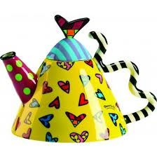 a yellow teapot with colorful designs on it's sides and a striped handle