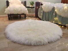 a living room with white fur rugs and lights on the wall behind it, along with two chairs