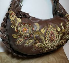 Elegant Festival Bags With Tassels, Designer Gold Embroidered Shoulder Bag, Designer Embroidered Gold Shoulder Bag, Brown Embellished Luxury Bag, Luxury Brown Embellished Bags, Elegant Brown Shoulder Bag With Tassels, Luxury Embellished Brown Bag, Designer Embellished Shoulder Bag, Designer Embellished Shoulder Bag For Everyday Use