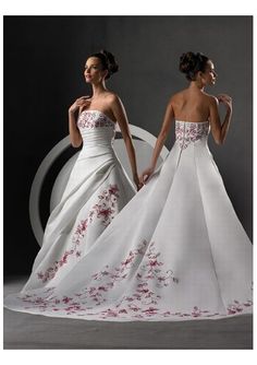 two women in wedding dresses, one is white and the other has red flowers on it