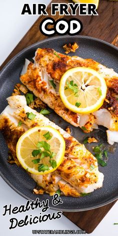 two pieces of fish on a plate with lemons