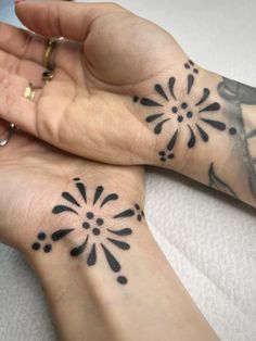 two people with matching tattoos on their hands