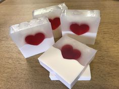 four pieces of soap with red liquid in them sitting on a table next to each other