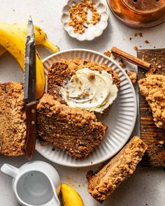 two slices of banana bread on a plate next to some bananas and cinnamon sticks with butter