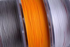 two spools of orange and silver pla