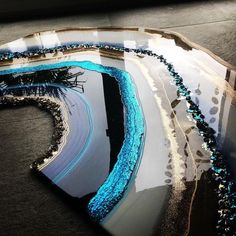 an artistic photo of a train track with blue beads on it's tracks and in the background there is a window