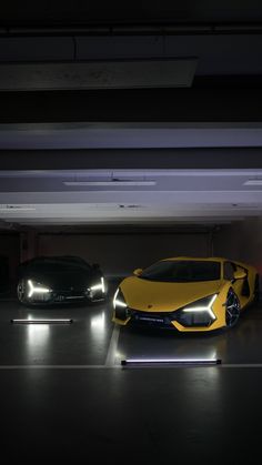 two cars parked in a parking garage with their lights on and one car is yellow