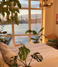 a bedroom with a large window overlooking the water and cityscape in the distance