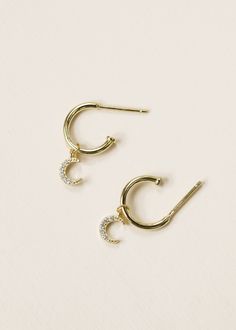 Welcome to the Golden Collection - Take your earring stack to new heights with this limited edition launch A delicate bend of a hoop, with a CZ encrusted crescent moon charm - an easy every day wearable.14kt gold vermeil over 925 sterling silverWhite Cubic Zirconia Outer diameter 12mmStraight bar post with backingNon-affixed charm Bar Post, Earring Stack, Golden Hoops, Moon Charm, Jewelry Earrings Hoops, Gold Hoop Earrings, 14kt Gold, Crescent Moon, Ring Bracelet