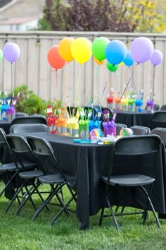 there are many balloons on the table at this birthday party, and it's colorful