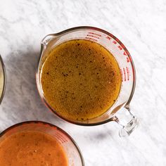 two blenders filled with different types of food on top of a white countertop